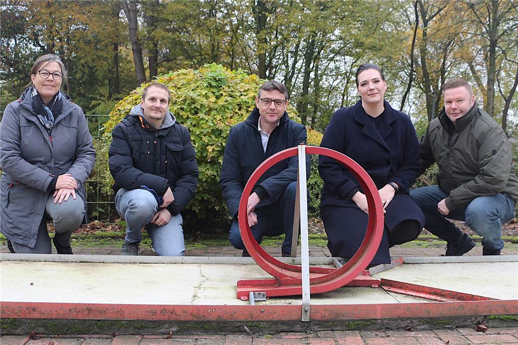 fünf Personen hinter einer Minigolfbahn