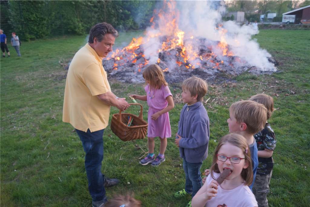 In Werne finden wieder Osterfeuer statt - aber mit besonderen Auflagen Carsten Grewe verteilt vor dem Osterfeuer Süßigkeiten an Kinder