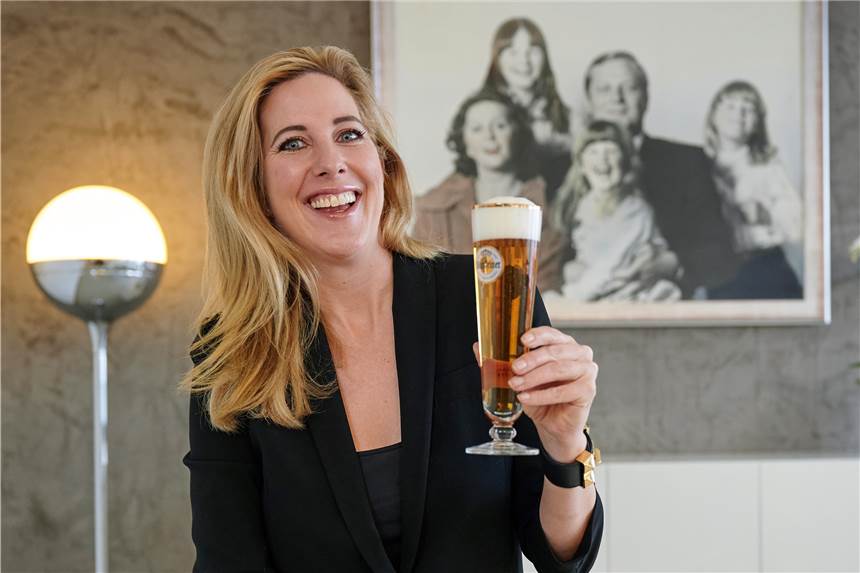 Bier ist reine „Männersache“? Falsch! Frauen beweisen das Gegenteil Catharina Cramer, Inhaberin des Brauerei-Unternehmens Warsteiner, sitzt mit einem Glas Bier in ihrem Büro. Im Hintergrund hängt ein Familienfoto, auf dem sie bei ihrem Vater Albert auf dem Schoß sitzt.