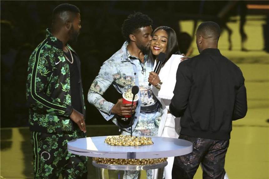 Oscar-Gala: Neue Ideen für die Trophäen-Show Chadwick Boseman (2.v.l) küsst Moderatorin Tiffany Haddish während der Verleihung eines MTV-Awards für den Besten Film „Black Panther“. Foto: Matt Sayles/Invision/AP