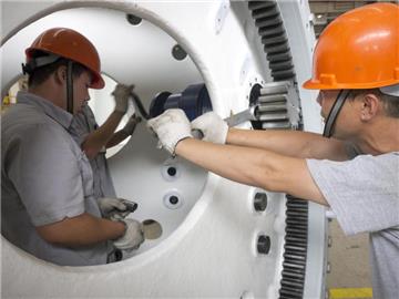 Chinesische Arbeiter bei der Fertigung einer Windkraftanlage. Foto: Adrian Bradshaw