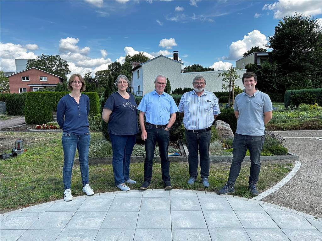„Der Friedhof lebt“: Der biodiverse Urnengarten in Lünen Christa Korthoff von der Friedhofsverwaltung, Verwaltungsreferentin Beate Galler, Kirchenvorstandsmitglied Frank Grundner, Norbert und Fabian Baasner von der Baasner Friedhof GmbH (von links) am Andachtsplatz vor dem Urnengarten. Hier dürfen Trauernde Blumen und Kerzen für ihre Lieben ablegen.