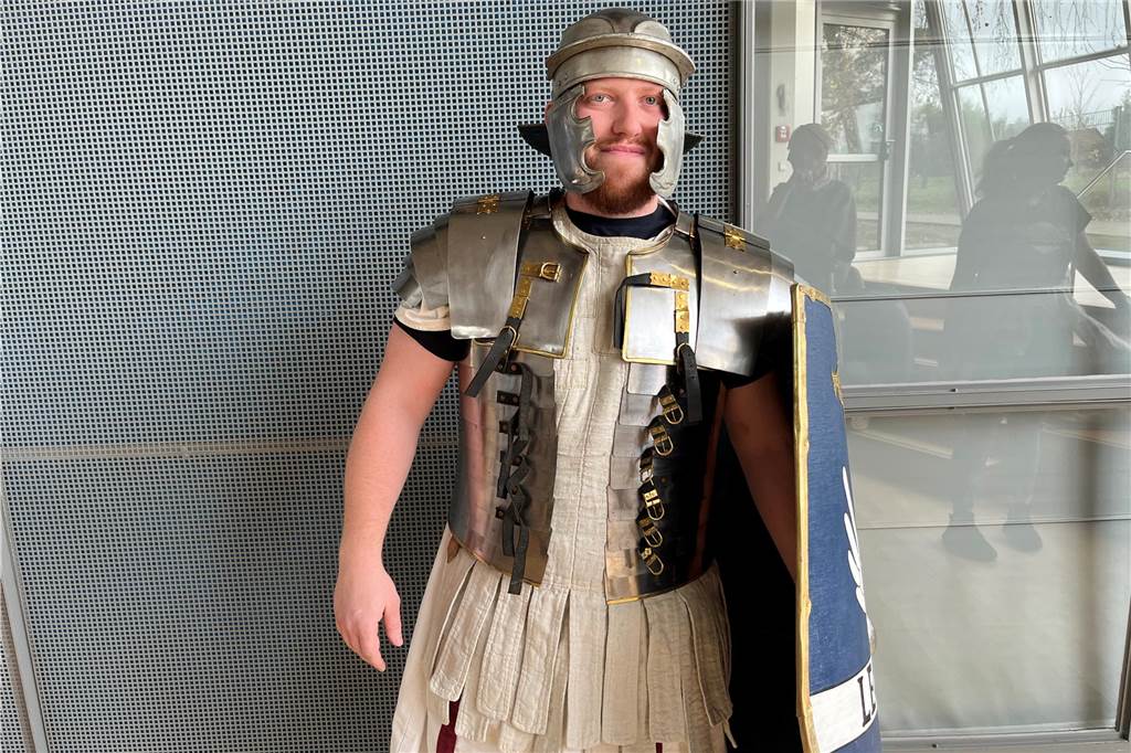Gut besuchte Geburtstagsfeier im Römermuseum: „Römer gehen immer“ Mann trägt eine Römer-Rüstung und hält in der linken Hand ein Schutzschild.