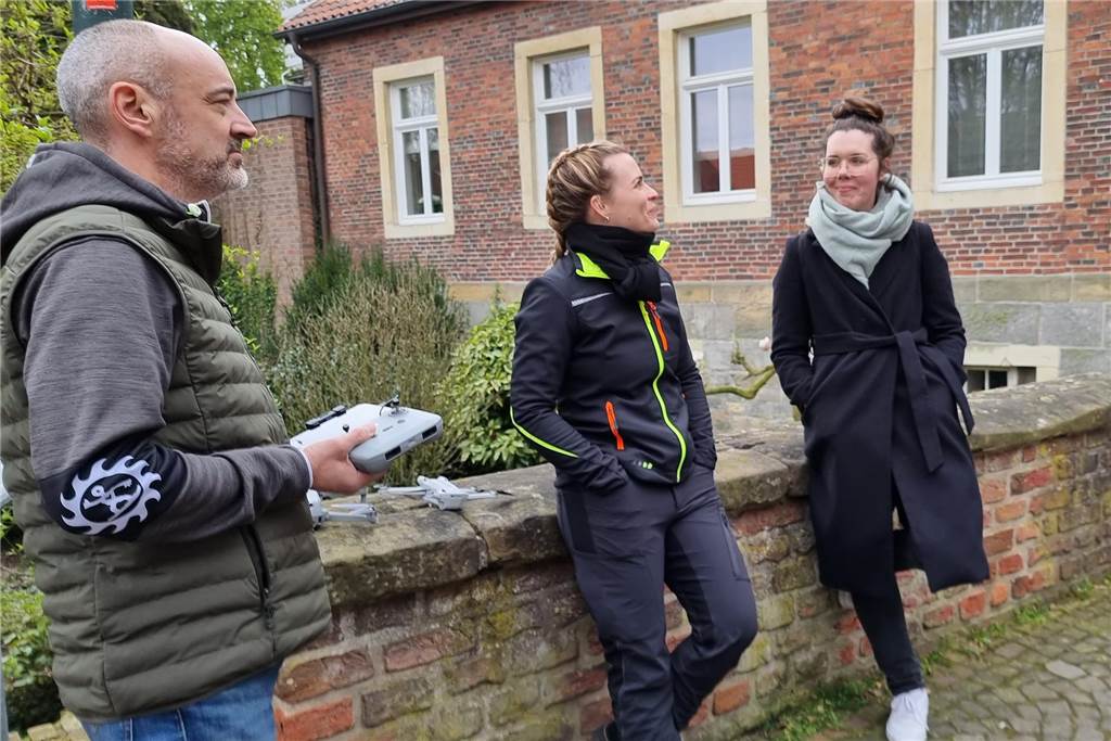 Christine Kolm vom Münsterland e.V (r.) und das Producerteam nehmen es entspannt, dass das Entfernen des Bannes am Burgtor nicht auf Anhieb funktionierte.