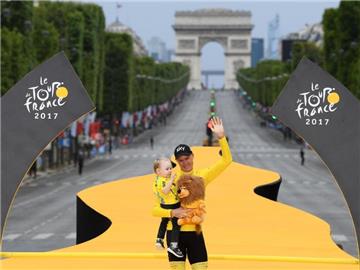 Christopher Froome (M) vom Team Sky steht mit seinem Sohn auf dem Podium in Paris. Foto: Pool Franck Faugere