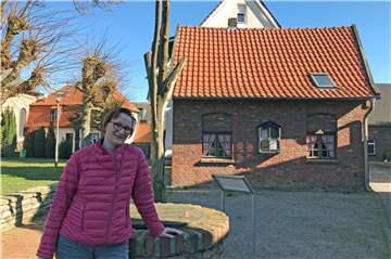 Claudia Boll liebt Rhade. „Ich will hier nicht mehr weg." Sie engagiert sich im Heimatverein und mag besonders das Soggeberghaus, ein Stück Rhader Geschichte. Es ist im Hintergrund zu sehen.