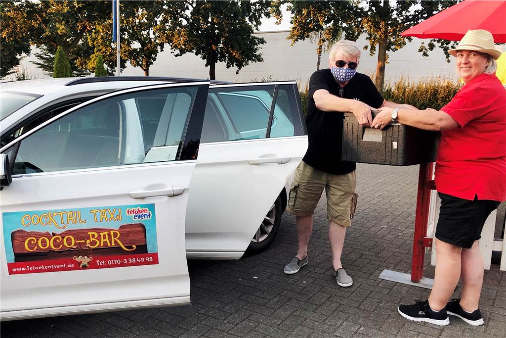 Kreativ gegen Coronafrust: Der Cuba Libre kommt per Cocktail-Taxi Cocktail-Taxi-Fahrer Detlef Müller nimmt aus den Händen von Elke Telöken eine Kühlbox mit Cocktails für die Auslieferung in Empfang.