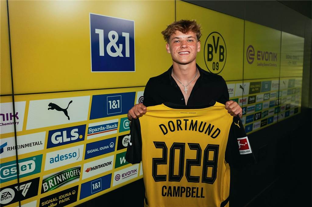 Cole Campbell hält ein Trikot in der Hand.
