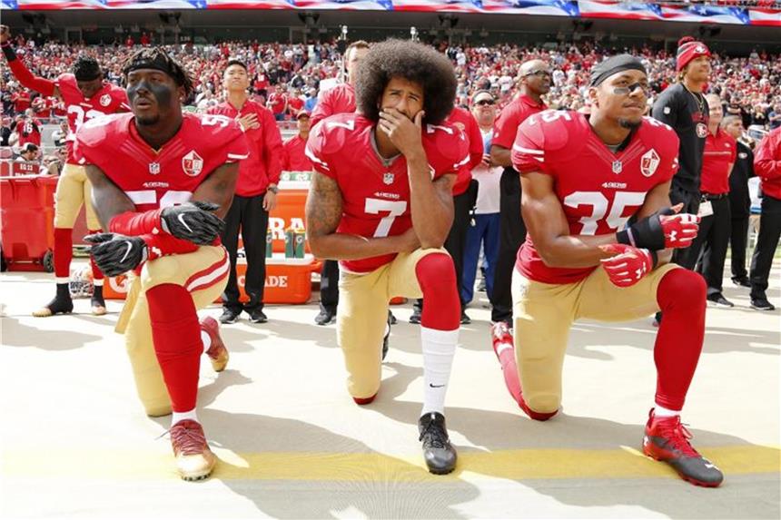 Trump fordert Sperren für Hymnen-Proteste in der NFL Colin Kaepernick (M), Eli Harold (l) und Eric Reid von den San Francisco 49ers knien beim Abspielen der Hymne. Foto: John G Mabanglo/AP