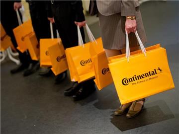 Continental Mitarbeiter verteilen Taschen mit dem Geschäftsbericht. Foto: Julian Stratenschulte/Archiv