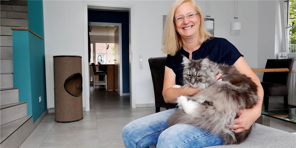 Cornelia Althoff mit Kater Wolfgang in ihrem Wohnzimmer, das nach dem Wohnungsbrand von der Bodenfliese bis zum Deckenanstrich erneuert werden musste. „Hier war alles schwarz!“ 
