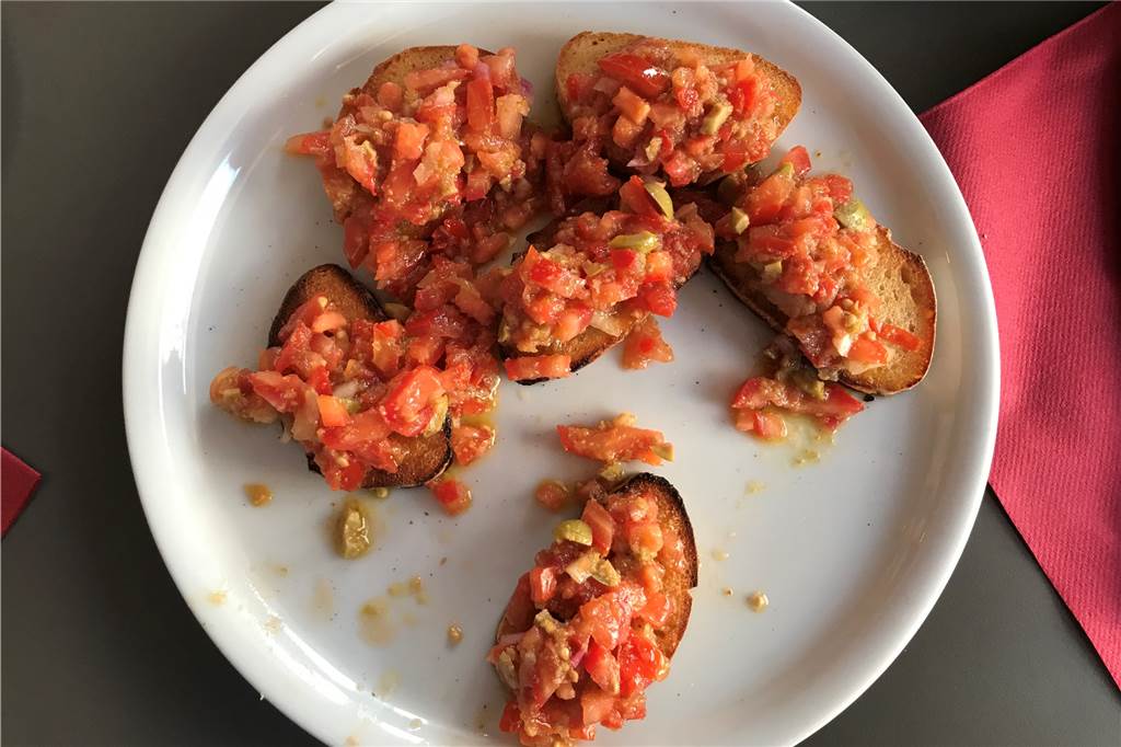 Pizzeria La Piccola: Es kommt nicht immer auf die Größe an Crosses Brot mit vielen Tomaten und Oliven: Bruschetta Classica.