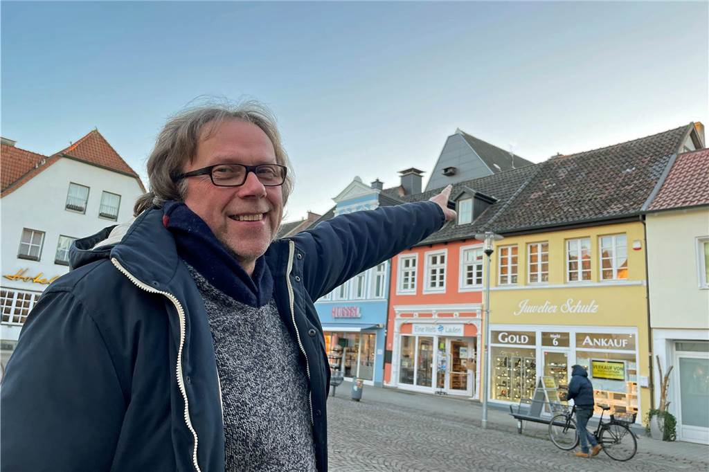 Blick über die Stadtgrenze: Wie gehen andere Kommunen mit Tauben um? Ein Mann zeigt auf ein Gebäude in Werne.