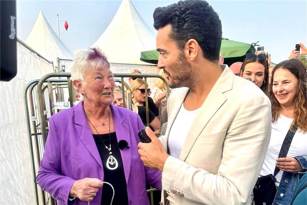 Giovanni Zarrella spricht mit Uschi Pathmann auf dem Konzertgelände vor einem Zelt.