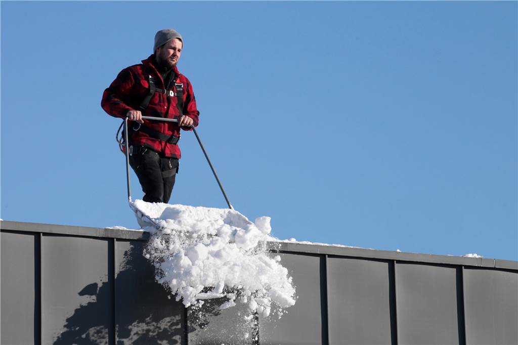 Lünen versinkt vor einem Jahr im Schnee - und wo ist nun der Winter? Dachdecker räumten - wie hier beim Aldi an der Cappenberger Straße - die Flachdächer von den Schneemassen.