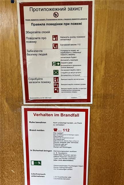 Blick in die städtische Notunterkunft für Flüchtlinge aus der Ukraine "Verhalten im Brandfall" auf Ukrainisch.