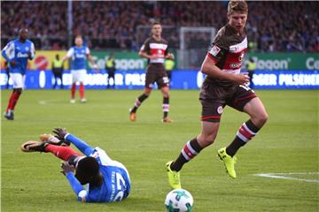 Daniel Buballa (r) kann sich gegen den Kieler Kingsley Schindler durchsetzen, der beim Zweikampf um den Ball stürzt. Foto: Axel Heimken