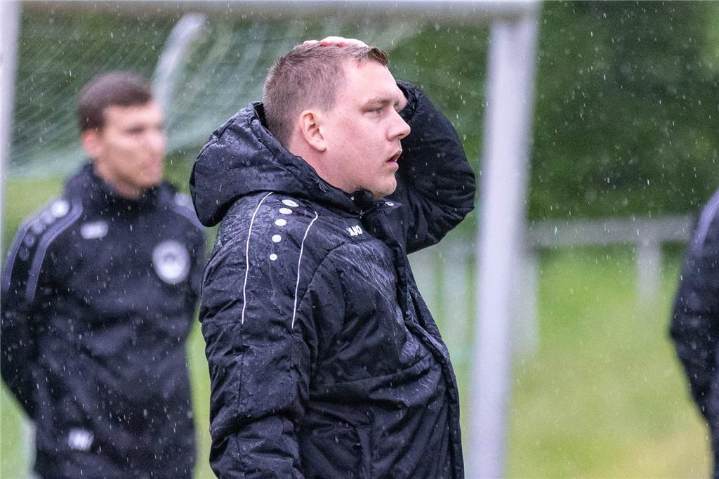 Rot für Teamoffiziellen: Co-Trainer stellt Gegenspieler Beinchen Daniel Pilzecker hat eine Hand an seinem Kopf, er steht im Regen.