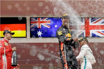 Daniel Ricciardo (M.) bejubelt seinen Sieg vor Sebastian Vettel (l.) und Lewis Hamilton.