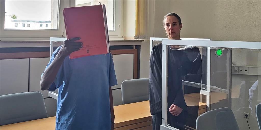 „Schreier“ wieder auf freiem Fuß – Therapie aussichtslos Der Angeklagte neben seiner Verteidigerin im Essener Landgericht, er hält einen Aktenordner vor das Gesicht.