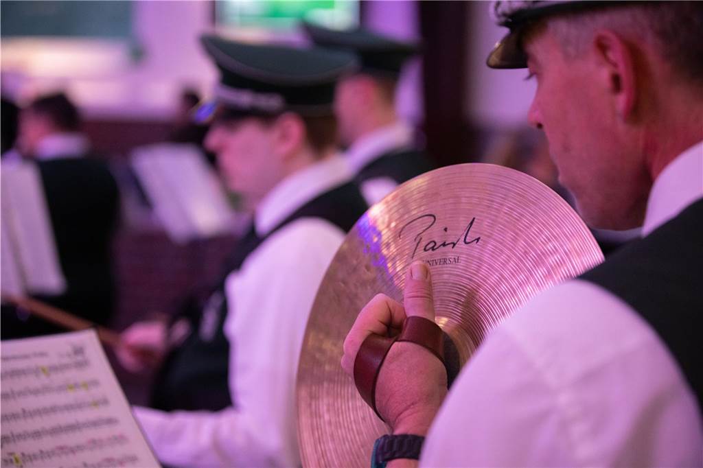 Ein Percussionist spielt die Becken vor einem Notenständer.