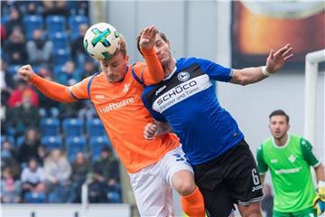 Darmstadts Fabian Holland (l.) und Bielefelds Tom Schütz kämpfen um den Ball. Foto: Guido Kirchner