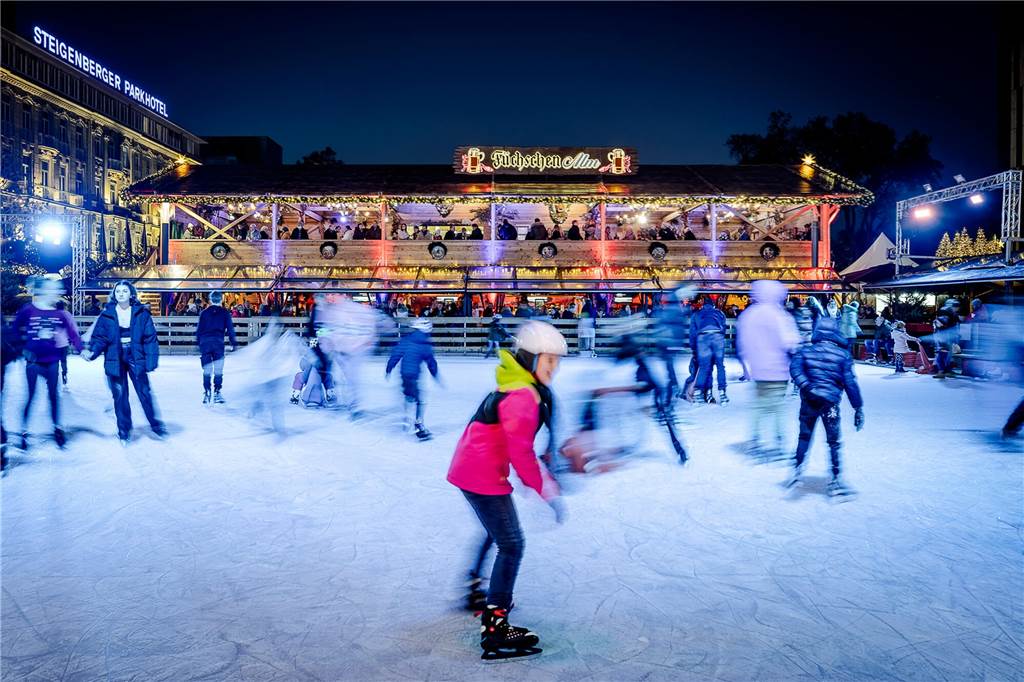 Heiß auf Eis? Die besten Schlittschuhbahnen im Winter 2022/23 menschen beim schlittschuhlaufen