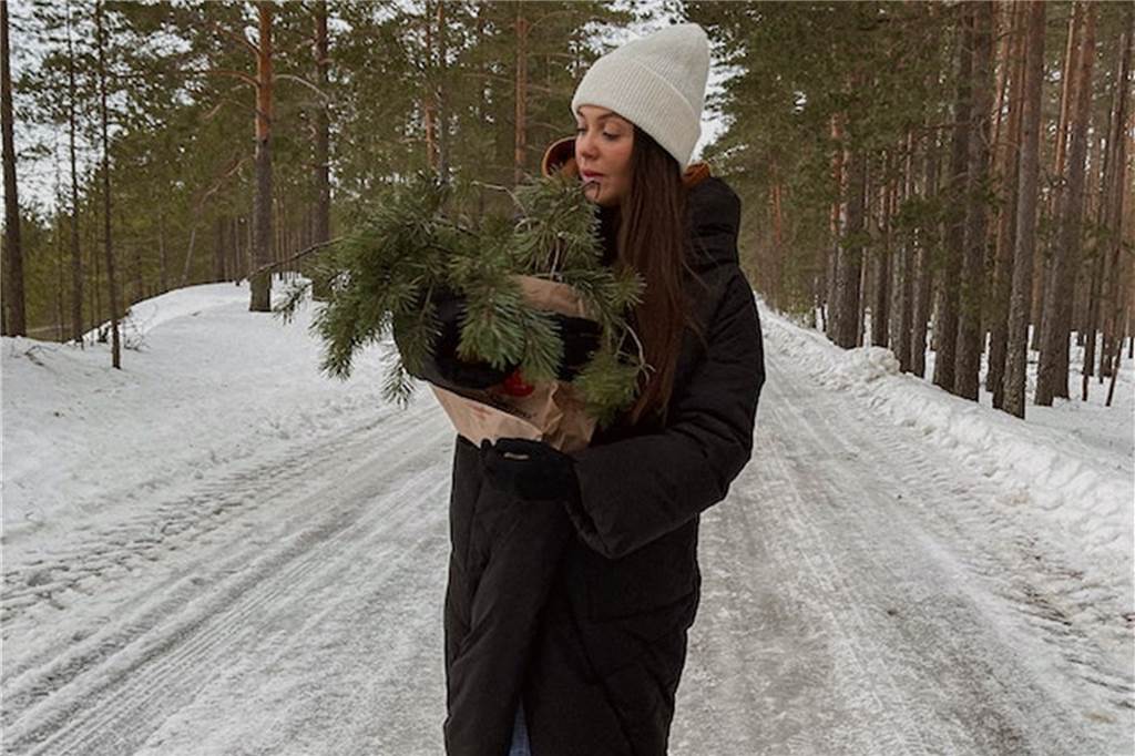 Familienausflug: Hier können Sie Weihnachtsbäume selbst schlagen frau trägt zweige durch einen wald