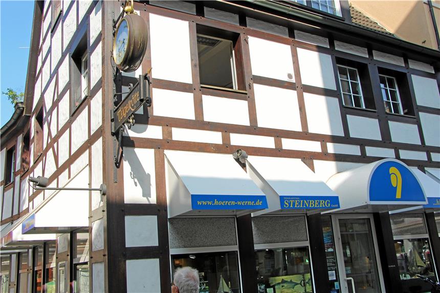 Werbung und massive Vordächer trüben den guten Eindruck Das auf alt getrimmte Werbeschild mit der Uhr passt hervorragend zum Fachwerk, die blaue Werbung schräg darunter nicht.
