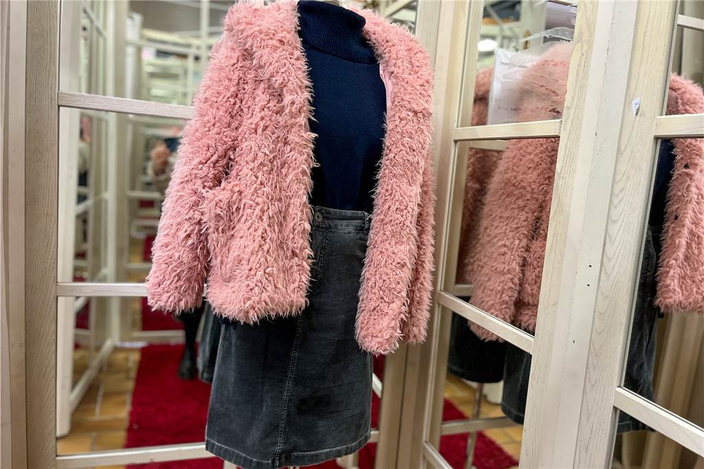 Second-Hand in Haltern: Schön ist, was gefällt und preiswert ist Eine Schaufensterpuppe trägt ein ausgefallenes Outfit: rosafarbene Plüschjacke, schwarzer Cord-Minirock und ein dunkelblauer Rollkragen-Pullover.