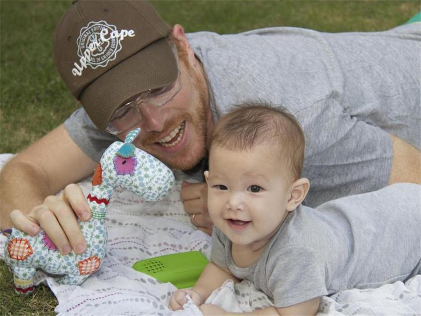 Schwules Paar kämpft in Thailand um Baby Carmen Das Baby Carmen Santos-Lake und ihr Vater spielen in Bangkok auf einer Decke. Der Amerikaner Gordon Lake und sein Partner, Spanier Manuel Santos, kämpfen in Thailand um ihr Baby, das von einer Leihmutter ausgetragen wurde. Foto: dpa