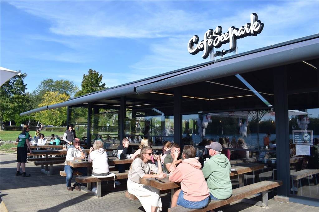 Leute sitzen auf der Terrasse des Cafes Seepark