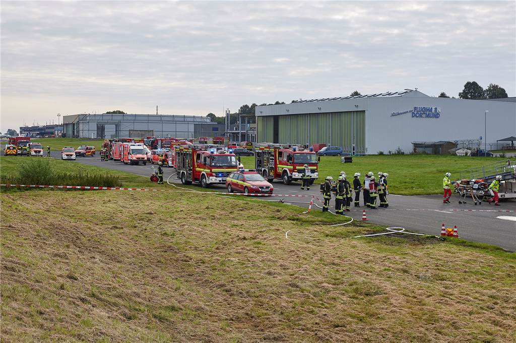 Mehrere Einsatzwagen und ein Gewimmel aus Einsatzkräften: Lagebild des Einsatzes am Flughafen