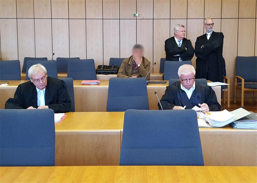 Patienten gegen Bezahlung krank geschrieben? Das Bild zeigt den Platz, auf dem eigentlich der angeklagte Arzt hätte Platz nehmen sollen. Im Hintergrund ein weiterer Angeklagter.