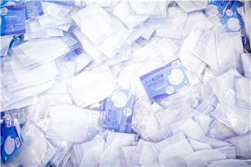 Das Bild zeigt fertig verpackte FFP2-Schutzmasken in einer Tonne in einer Produktionsstätte. 