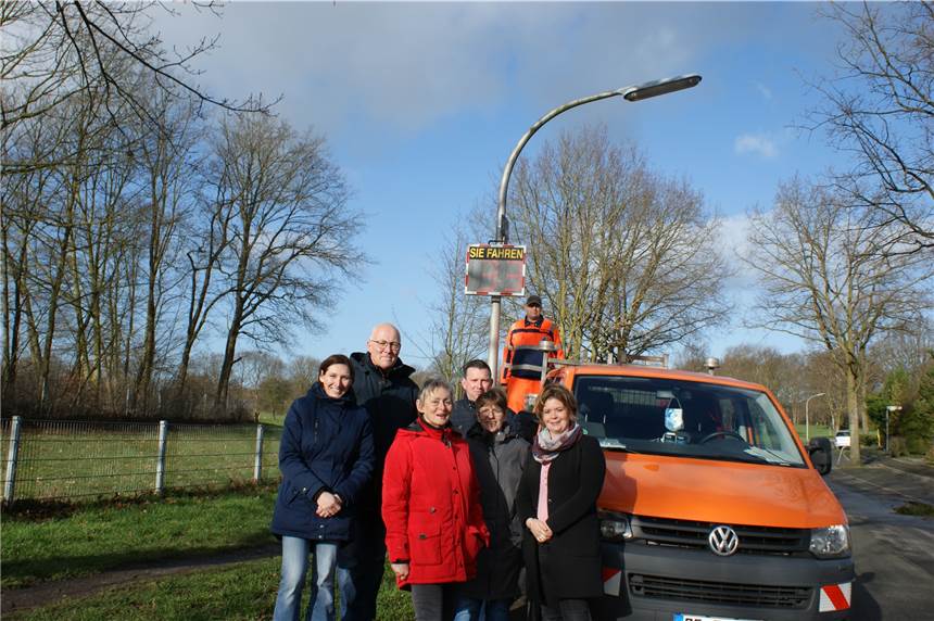 Tempomesstafel hängt dort, wo Autofahrer schon mal stärker aufs Gaspedal treten Das Bild zeigt (v.l.) die Anwohner und Initiatoren Yvonne Sebus, Wolfgang Ittner, Gabriele Kleffmann, Christoph Hillebrand, Gabi Lorsbach und Katrin Hillebrand sowie auf der Ladefläche des Transporters Hubert Feldmann, Mitarbeiter des städtischen Bauhofs, der gemeinsam mit seinen Kollegen Michael Miksche und Christian Grote die Tempomesstafel an der Bonifatiusstraße installiert hat.