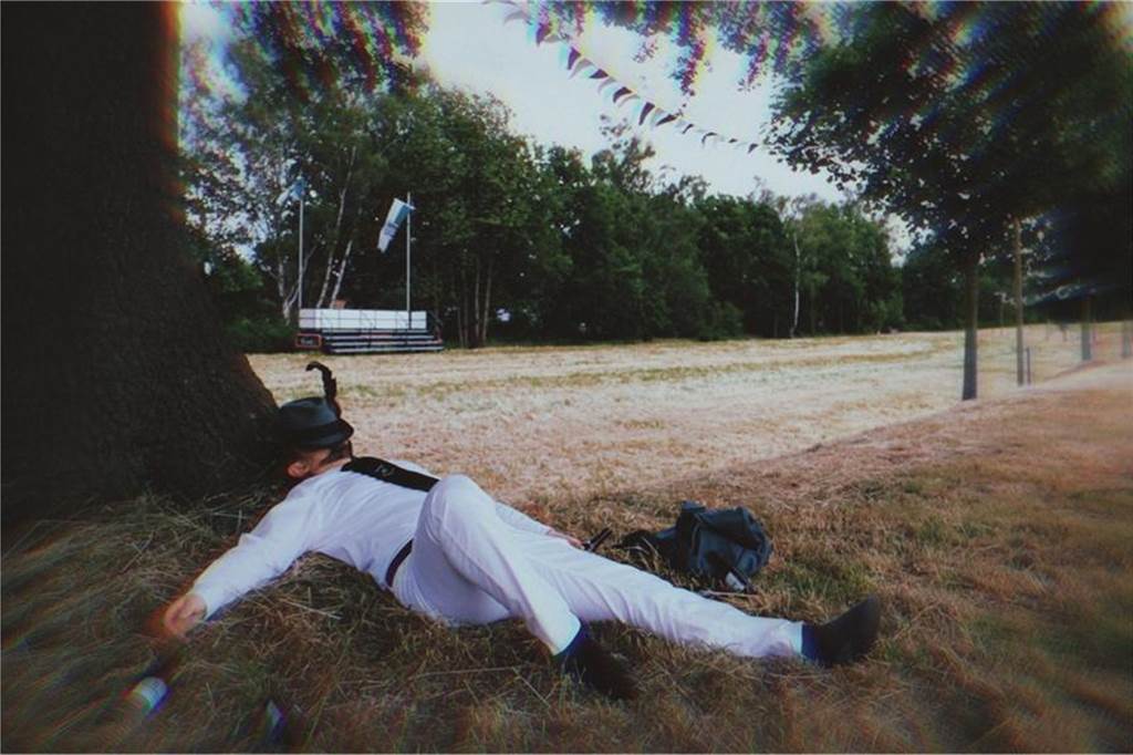 Alexander Büning (26) aus Dorsten veröffentlicht Song über Schützenfeste (mit Video) Auf dem Foto des Song-Covers liegt Alexander Büning vor der Festwiese der Feldmarker Schützen.