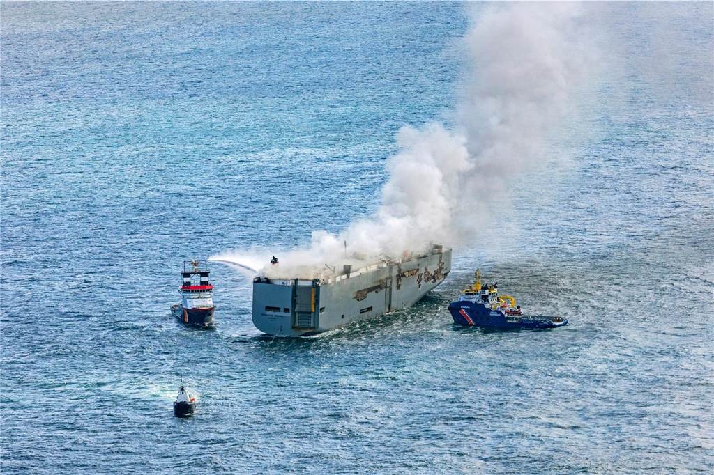 Riskantes Schlepp-Manöver von brennendem Frachter begonnen: Umweltverseuchung droht Eine Luftaufnahme zeigt den deutschen Notschlepper "Nordic" (l), der das Feuer auf einem brennenden Frachter in der Nordsee bekämpft. Rechts ist das Boot "Guardian" der niederländischen Küstenwacht zu sehen. Wie die niederländische Küstenwache mitteilte, war auf dem Frachtschiff mit rund 3000 Autos an Bord ein Feuer ausgebrochen. Ein Mensch sei ums Leben gekommen. Die übrigen Mitglieder der Besatzung konnten demnach gerettet werden, einige seien verletzt worden. Rettungskräfte sind im Einsatz, u