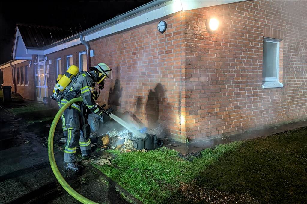 Feuer an Sportzentrum Dahl: Einsatzkräfte löschen brennende Mülltonnen Ein Feuerwehrmann löscht das Feuer am Sportzentrum in Werne.