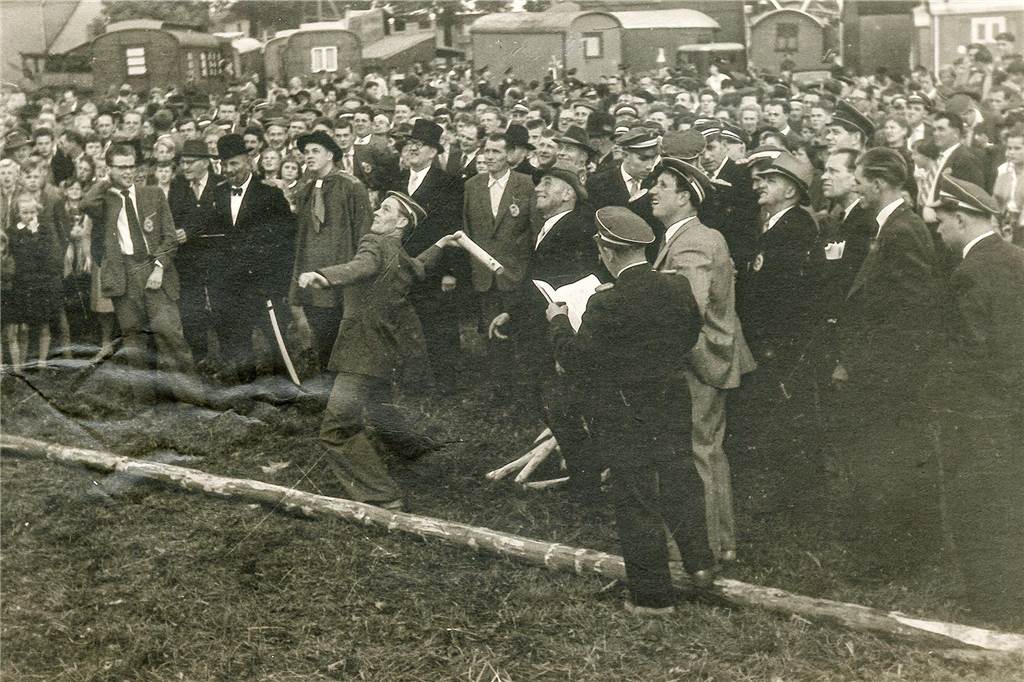 Eine Tradition auf dem Brezelfest: Woher kommt der Brezelkittel? Das Foto aus dem Jahr 1957 zeigt erstmals einen Gast auf dem Brezelfest in einem Kittel. Es war der damalige Brezelbäcker Hans Weber.
