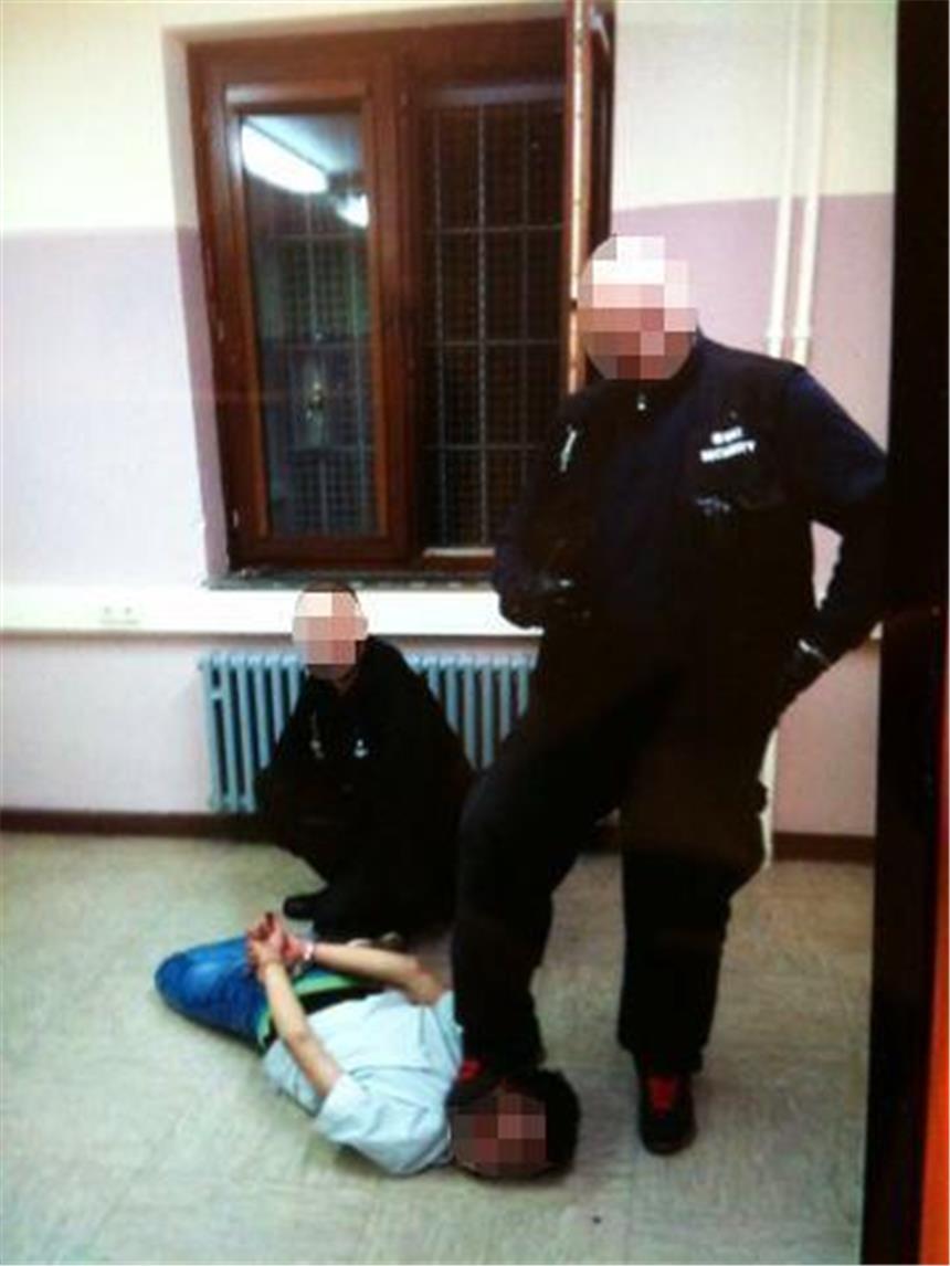 Sicherheitskräfte misshandeln Flüchtlinge Das Handout der Polizei zeigt zwei Sicherheitsleute, die in der ehemaligen Siegerland-Kaserne in Burbach einen am Boden liegenden Flüchtling misshandeln.