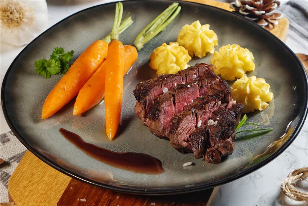 Das Hauptgericht des Weihnachts-Menüs: Rinderfilet an Rotweinsauce mit Herzoginkartoffeln und glasierten Kardamom-Möhren.