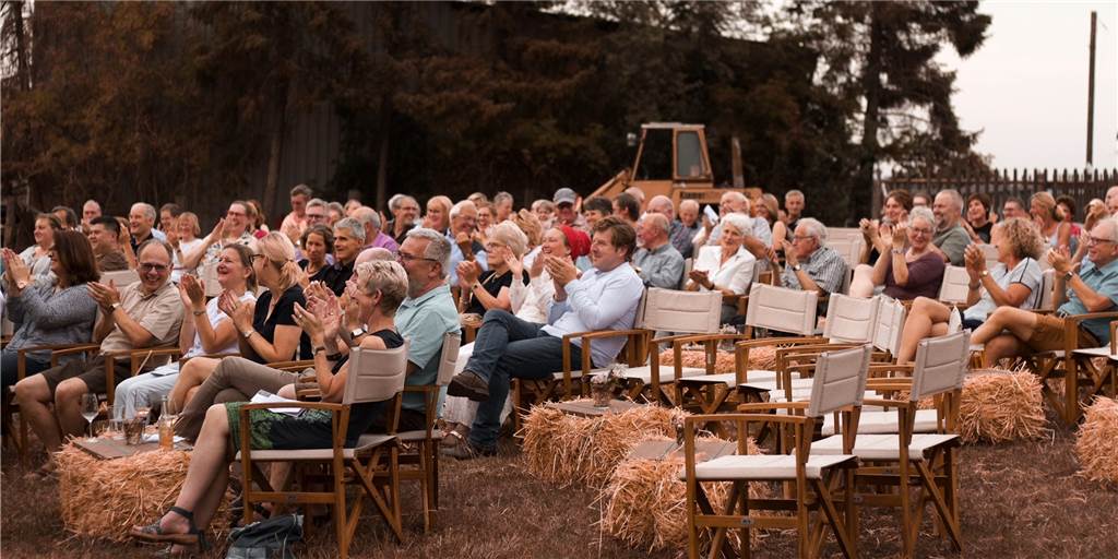 Das kühle Getränk steht griffbereit auf dem Strohballen neben dem bequemen Regiestuhl: Die rustikale Atmosphäre schätzen die Besucher des Hofmusik Festivals, das dieses Jahr in den Innenhof von Gut Nordhausen umzieht.