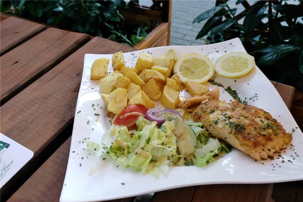 Das Lachsfilet vom Grill überzeugt uns sehr. Der Salat mit Honig-Senf-Dressing ist frisch, so auch die Patatas bravas. Dazu gibt es allerdings keine Soße.