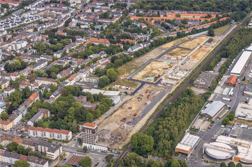 Lärmschutz für neues Wohngebiet: Hier entsteht Dortmunds größte Wand Das Luftbild zeigt die gesamte Ausdehnung des Baugebiets hinter dem Wasserturm am Heiligen Weg. Entlang der S-Bahn-Strecke entsteht die Lärmschutzwand, ganz rechts ist der Großmarkt zu erkennen.