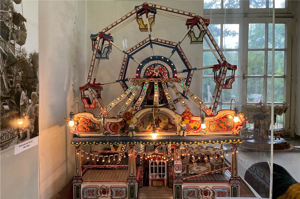 Das Modell des alten "Columbia-Rad" ist eine Dauerleihgabe der Familie Isken aus Dortmund. Das echte Fahrgeschäft hatte deutlich mehr Gondeln. Zuletzt war auf Sim-Jü meist das Riesenrad "Roue Parisienne" zu sehen. 2023 wird auf dem Platz am Hagen das "Columbia III" aufgebaut.
