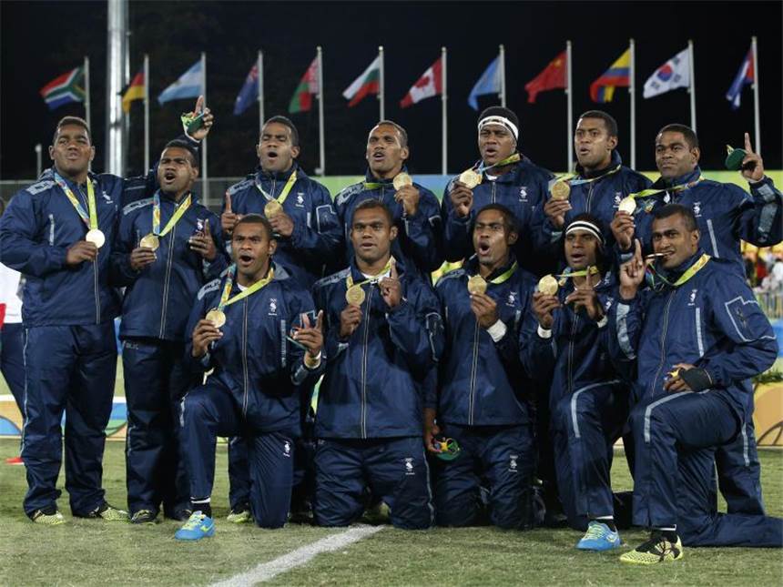 Nach erstem Fidschi-Gold: 22. August wird Feiertag Das Nationalteam im 7er-Rugby aus Fidschi posiert stolz mit der ersten Goldmedaille des Landes. Foto: Yoan Valat