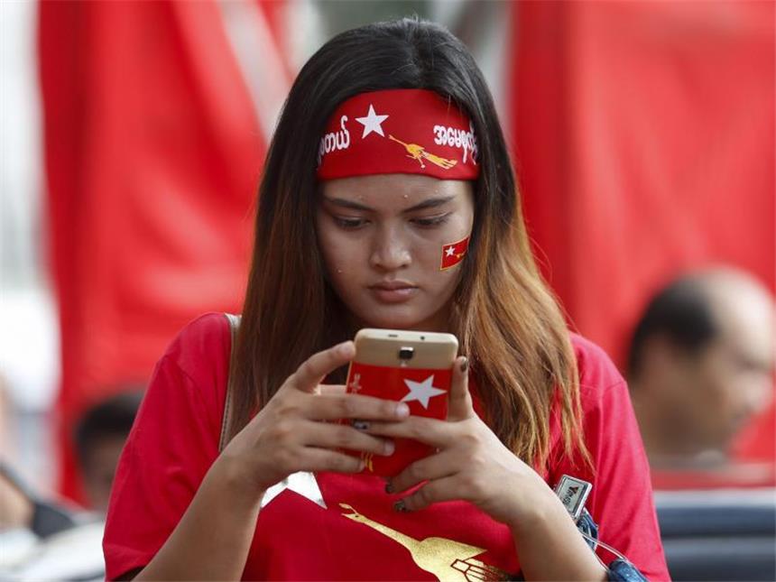 Suu Kyis Oppositionspartei in Myanmar vor großem Wahlsieg Das neue Myanmar: Per Smartphone tauscht sich eine Anhängerin der oppositionellen Nationalen Liga für Demokratie nach dem Wahlsieg aus. Foto: Lynn Bo Bo