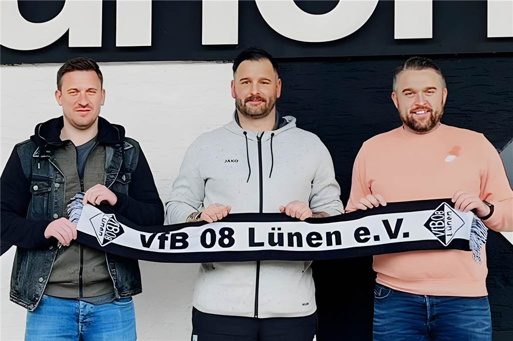 Ausrufezeichen des VfB Lünen Maik Küchler, Pascal Harder und Lukas Fluder halten einen VfB-Lünen-Schal in die Höhe.