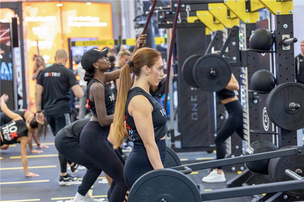 Auf der Fitnessmesse Fibo trainieren Personen an Kraftmaschinen.